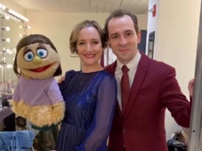 Rob Mcclure and Maggie Lakis are posing together for the camera as Lakis is holding the puppet in her hand.